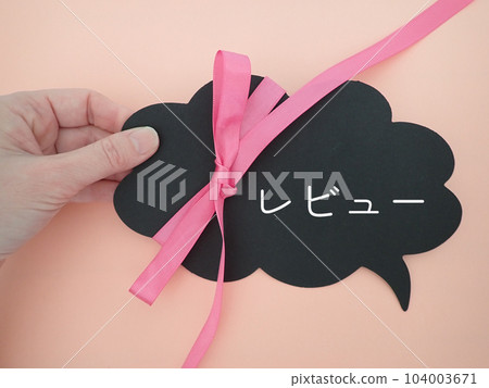 Review text on a speech bubble held with a finger Review text on a speech bubble held with a finger 104003671