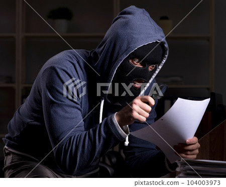 Male thief in balaclava in the office night time 104003973