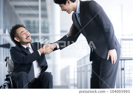 A businessman shaking hands A businessman in a wheelchair and a person who greets A businessman shaking hands A businessman in a wheelchair and a person who greets 104003993