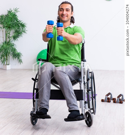 Young man in wheel-chair doing exercises indoors Young man in wheel-chair doing exercises indoors 104004274