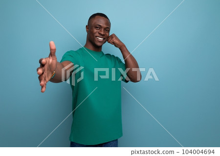 young friendly handsome african guy with short haircut dressed in a basic t-shirt smiling against young friendly handsome african guy with short haircut dressed in a basic t-shirt smiling against 104004694