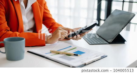 Businesswoman hands working with finances about cost and calculator and laptop with tablet, smartphone at office Businesswoman hands working with finances about cost and calculator and laptop with tablet, smartphone at office 104005513