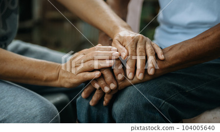 Hands of the old man and a woman hand on the wood table Hands of the old man and a woman hand on the wood table 104005640