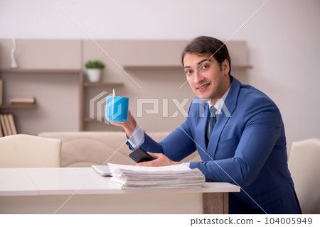 Young male employee working from home during pandemic Young male employee working from home during pandemic 104005949