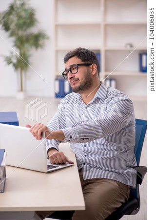 Young male employee working in the office 104006035