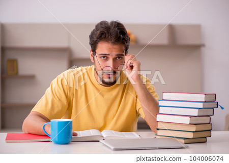 Young male student preparing for exams at home 104006074