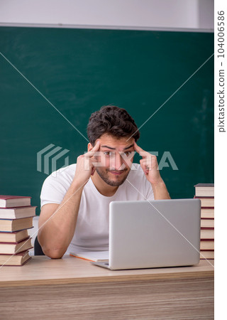 Young male student sitting in the classroom 104006586