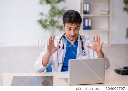 Young male doctor in telemedicine concept 104006707