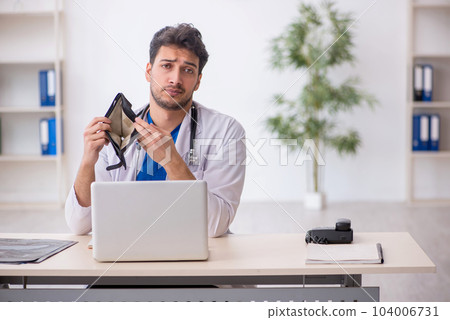 Young male doctor in remuneration concept 104006731