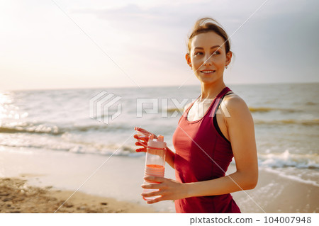 Young woman in sportswear doing yoga, fitness exerciseon the beach. Sport, Active life. 104007948