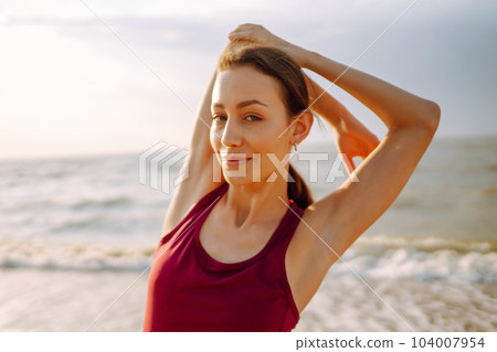 Young woman in sportswear doing yoga, fitness exerciseon the beach. Sport, Active life. 104007954