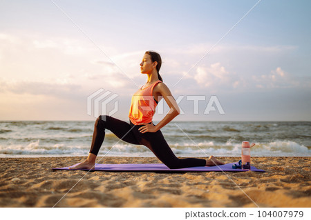 Young woman in sportswear doing yoga, fitness exerciseon the beach. Sport, Active life. Young woman in sportswear doing yoga, fitness exerciseon the beach. Sport, Active life. 104007979
