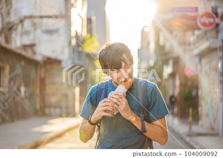 Man eating street food in Istanbul. Balik ekmek - fish in a bread, traditional Turkish fast food. Istanbul, Turkey 104009092