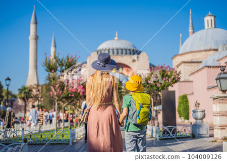 Mother and son Tourists enjoy beautiful view on Hagia Sophia Cathedral, famous islamic Landmark mosque, Travel to Istanbul, Turkey. Traveling with kids concept. Sunny day architecture and Hagia Sophia Mother and son Tourists enjoy beautiful view on Hagia Sophia Cathedral, famous islamic Landmark mosque, Travel to Istanbul, Turkey. Traveling with kids concept. Sunny day architecture and Hagia Sophia 104009126