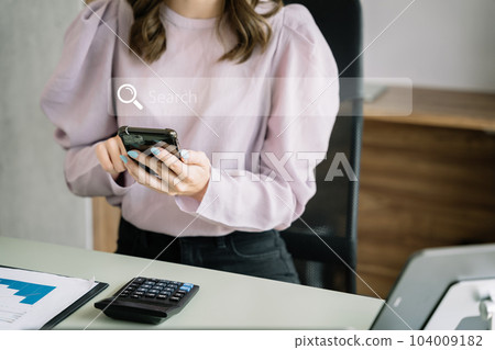 Woman uses a smartphne to search for information in the home in the morning. 104009182