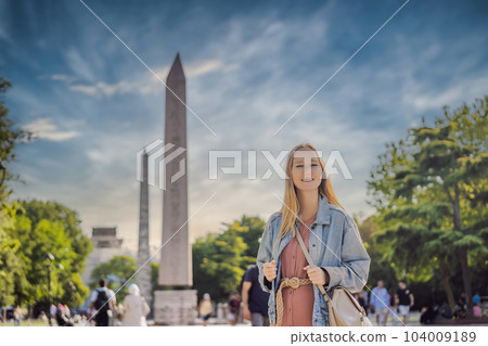 Woman Tourist in Istanbul against the background of Obelisk of Theodosius is the Ancient Egyptian obelisk of Pharaoh Thutmose III places in the Hippodrome of Constantinople, Turkey. Theodosius Woman Tourist in Istanbul against the background of Obelisk of Theodosius is the Ancient Egyptian obelisk of Pharaoh Thutmose III places in the Hippodrome of Constantinople, Turkey. Theodosius 104009189