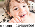 A close-up portrait headshot of a cute white Caucasian boy with long hair, looking directly at the camera and smiling 104009506
