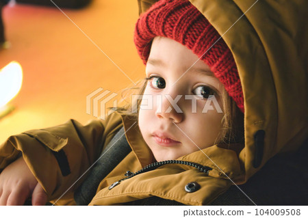 A young white Caucasian boy wearing thick winter clothes looking directly at the camera A young white Caucasian boy wearing thick winter clothes looking directly at the camera 104009508