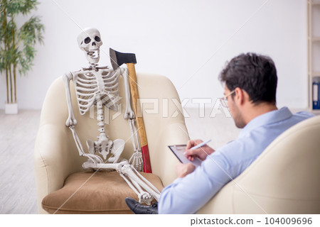 Young male psychologist meeting with skeleton Young male psychologist meeting with skeleton 104009696