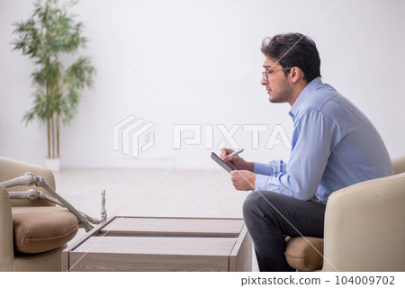 Young male psychologist meeting with skeleton 104009702