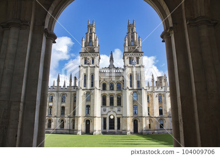 All Souls college, Oxford university - front view of entrance with towers and the green lawn from an archway 104009706