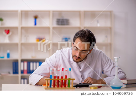 Young male chemist working at the lab 104009726