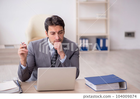 Young male employee working in the office Young male employee working in the office 104009874
