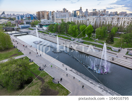 Embankment of the central pond and musical fountain. The historic center of the city of Yekaterinburg, Russia, Aerial View Embankment of the central pond and musical fountain. The historic center of the city of Yekaterinburg, Russia, Aerial View 104010795