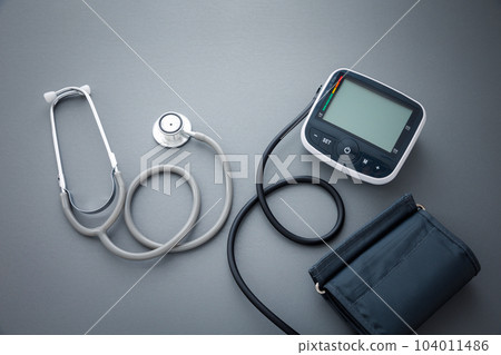 stethoscope with blood pressure measurement machine on dark grey background 104011486