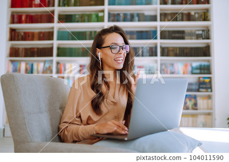 Online conference, training Student girl working with laptop, learning in college library. Freelance Online conference, training Student girl working with laptop, learning in college library. Freelance 104011590