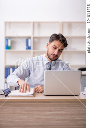 Young male employee working in the office 104011718