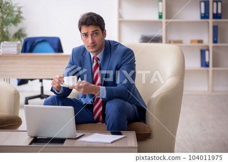 Young male employee sitting in the office Young male employee sitting in the office 104011975
