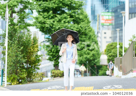 A woman going to work with a parasol 104012036