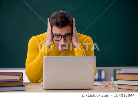 Young male student sitting in the classroom 104012044