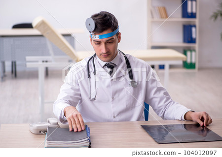 Young male doctor otolaryngologist working in the clinic 104012097