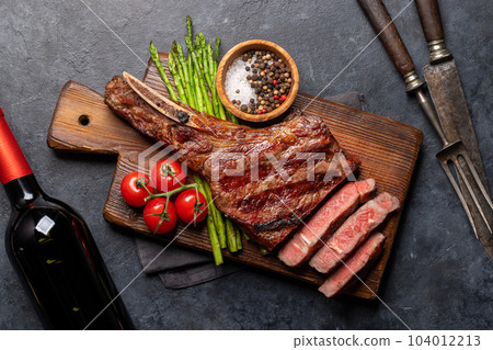 Medium rare grilled Tomahawk beef steak with asparagus Medium rare grilled Tomahawk beef steak with asparagus 104012213