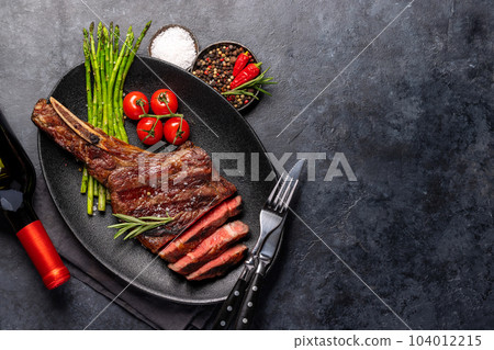 Medium rare grilled Tomahawk beef steak with asparagus Medium rare grilled Tomahawk beef steak with asparagus 104012215