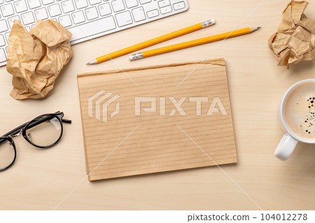 Top view of blank notepad, keyboard, coffee, apple and crumpled papers Top view of blank notepad, keyboard, coffee, apple and crumpled papers 104012278