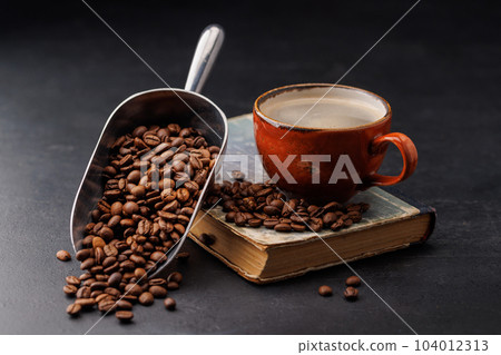 Rich coffee in a cup with aromatic roasted beans 104012313