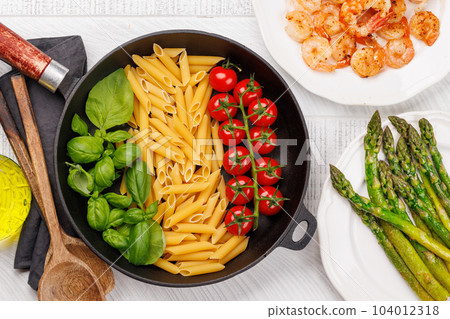 A vibrant representation of the Italian flag made with pasta, basil, and tomatoes A vibrant representation of the Italian flag made with pasta, basil, and tomatoes 104012318