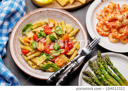 Italian pasta adorned with fresh tomatoes and aromatic basil Italian pasta adorned with fresh tomatoes and aromatic basil 104012322
