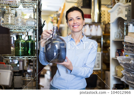 adults woman chooses glass decorative bottles 104012966