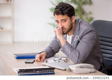 Young male employee working in the office 104013141