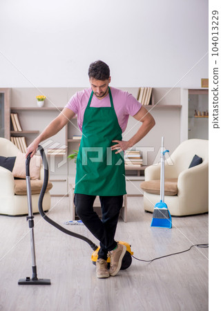 Young male contractor cleaning the house 104013229