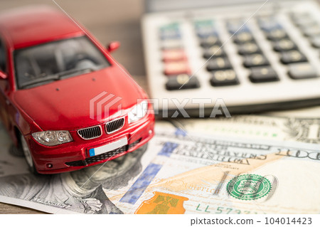BANGKOK, THAILAND - FEBRUARY 18, 2022, Car on US dollar and calculator; Car loan, Finance, saving money, insurance and leasing time concepts. 104014423
