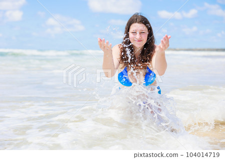 穿著泳衣的性感女孩在海灘上向鏡頭潑水 穿著泳衣的性感女孩在海灘上向鏡頭潑水 104014719