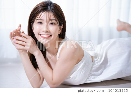 Young woman lying on flooring Young woman lying on flooring 104015325