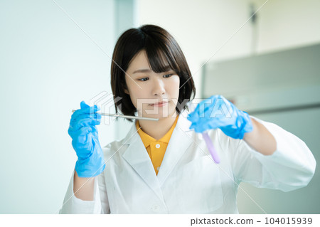 A woman in a white coat doing research A woman in a white coat doing research 104015939