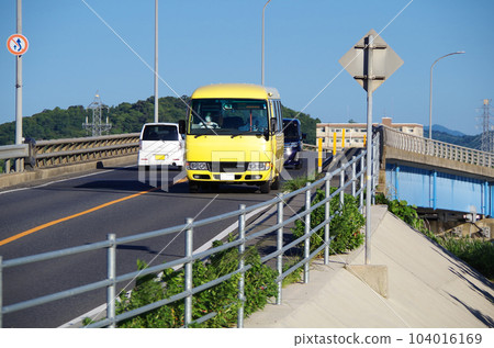 A scene of a wide-area life bus with a yellow body running on the road A scene of a wide-area life bus with a yellow body running on the road 104016169