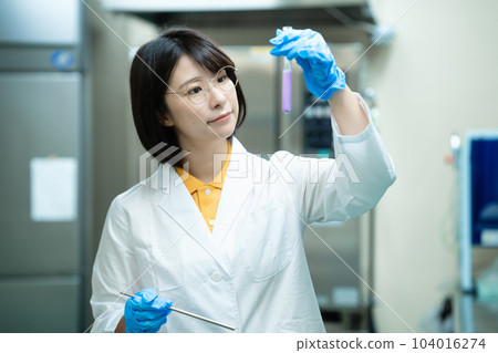 A woman in a white coat doing research 104016274